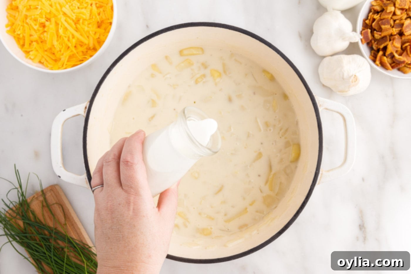 pouring heavy cream into baked potato soup