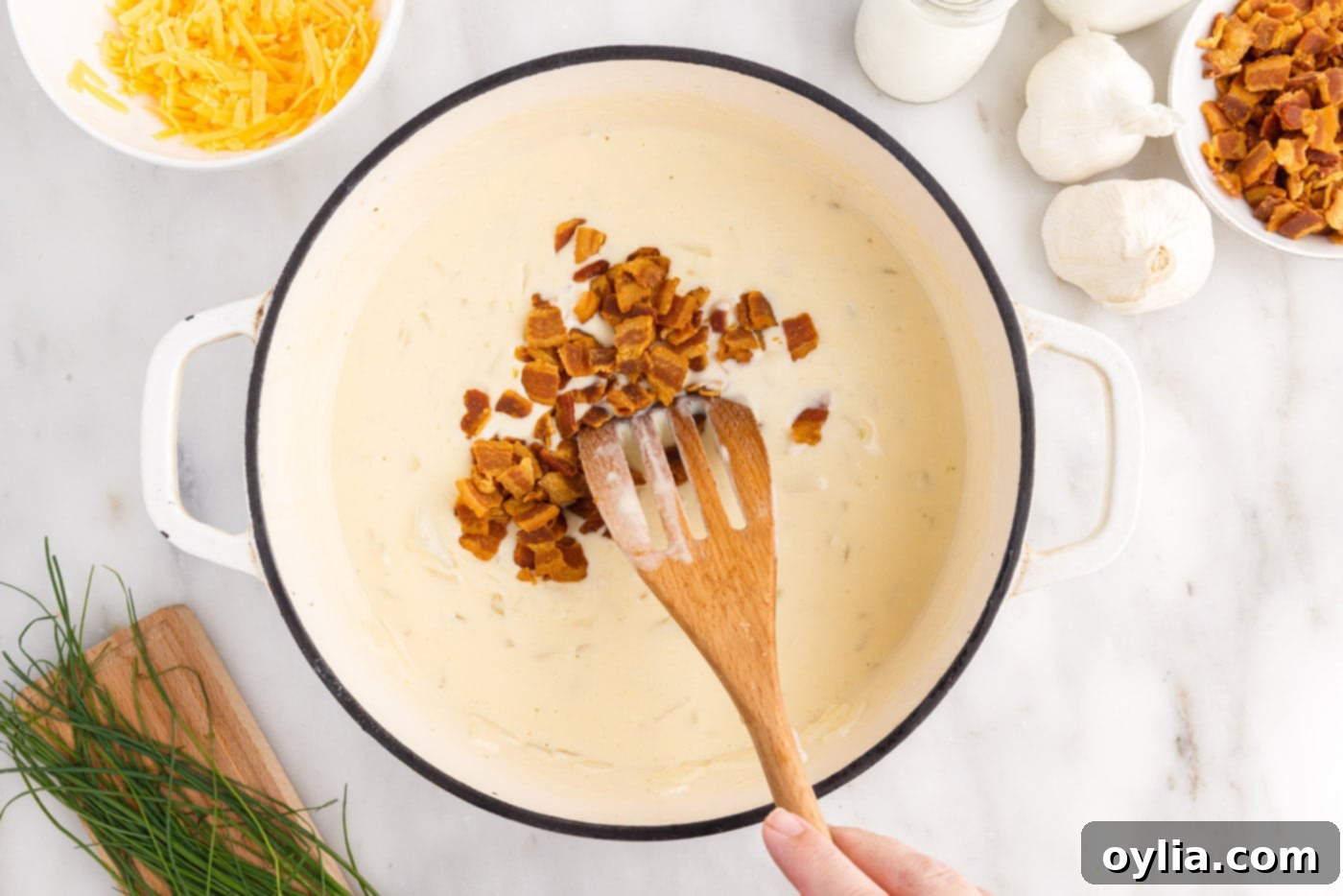 stirring crumbled bacon into baked potato soup