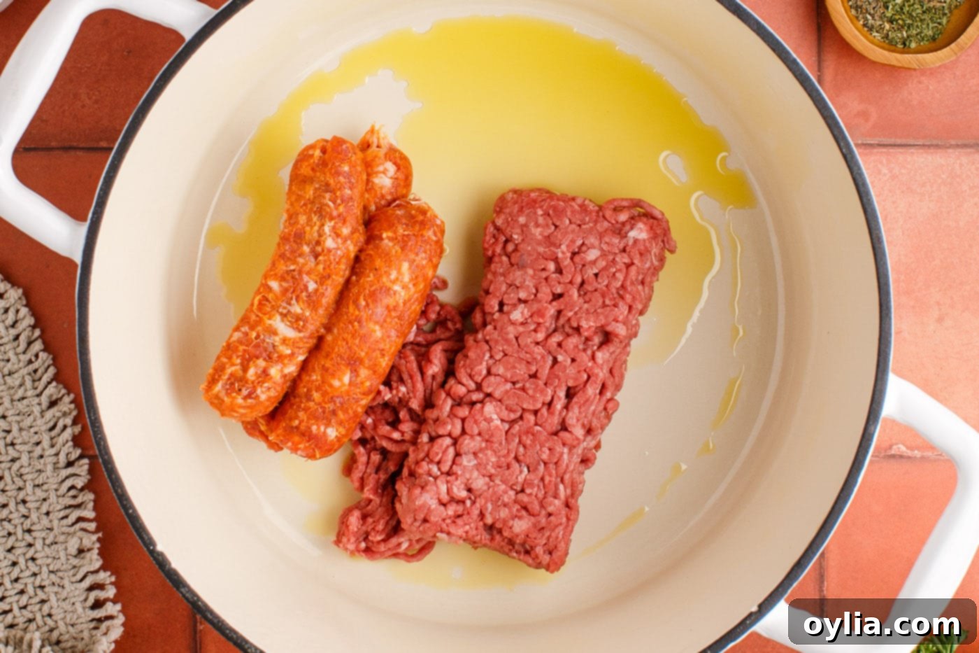 sausage and ground beef in a pot with oil