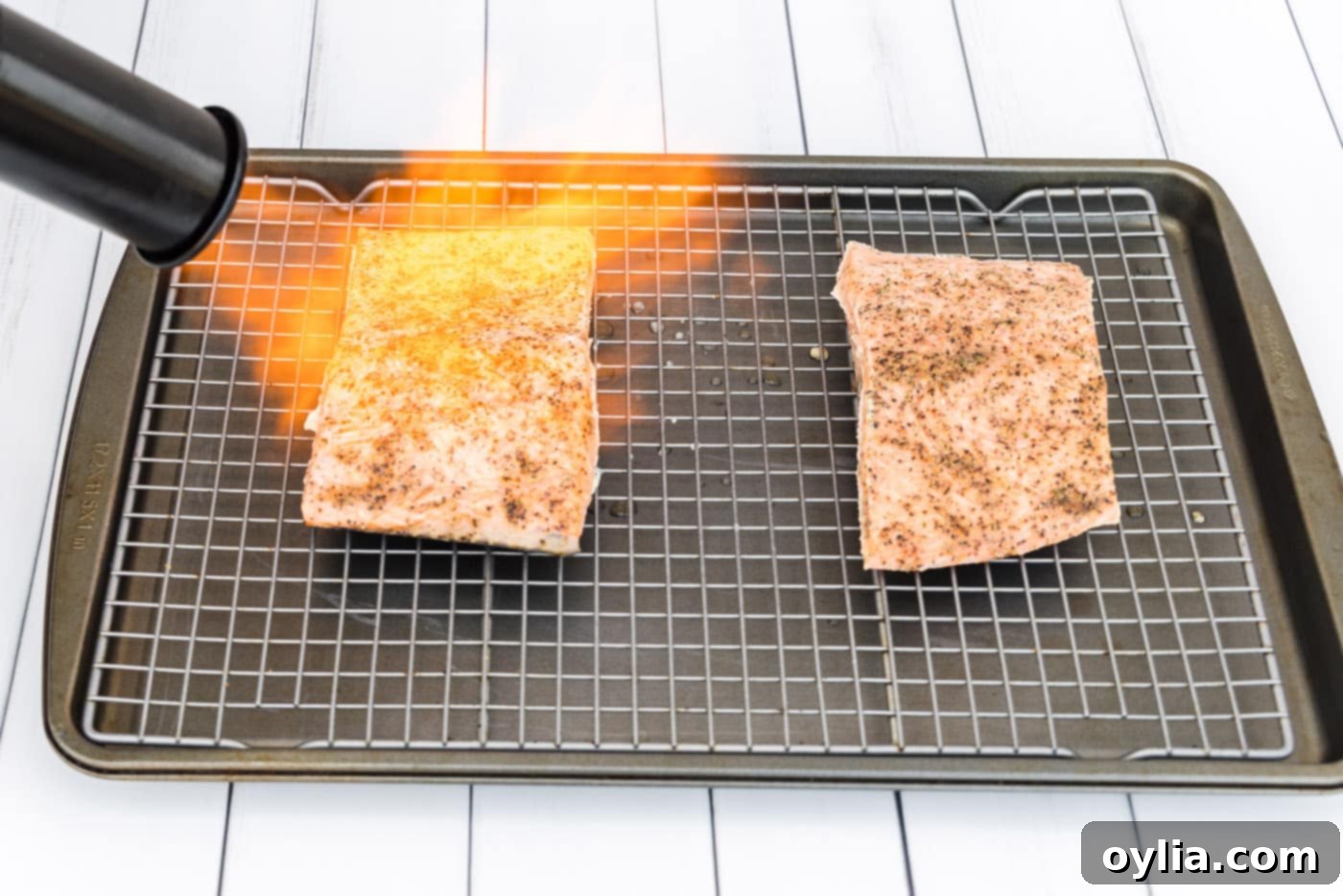Searing the exterior of sous vide cooked salmon filets with a kitchen torch to create a crispy crust