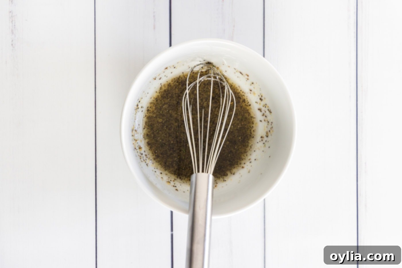Whisking olive oil, garlic salt, and black pepper in a small bowl for salmon seasoning