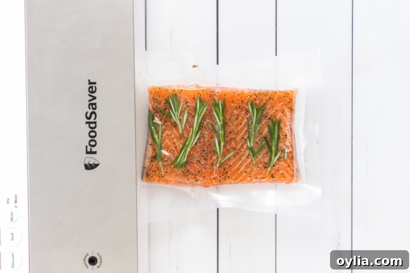 Two salmon filets with herbs inside vacuum seal bags, ready for sous vide cooking
