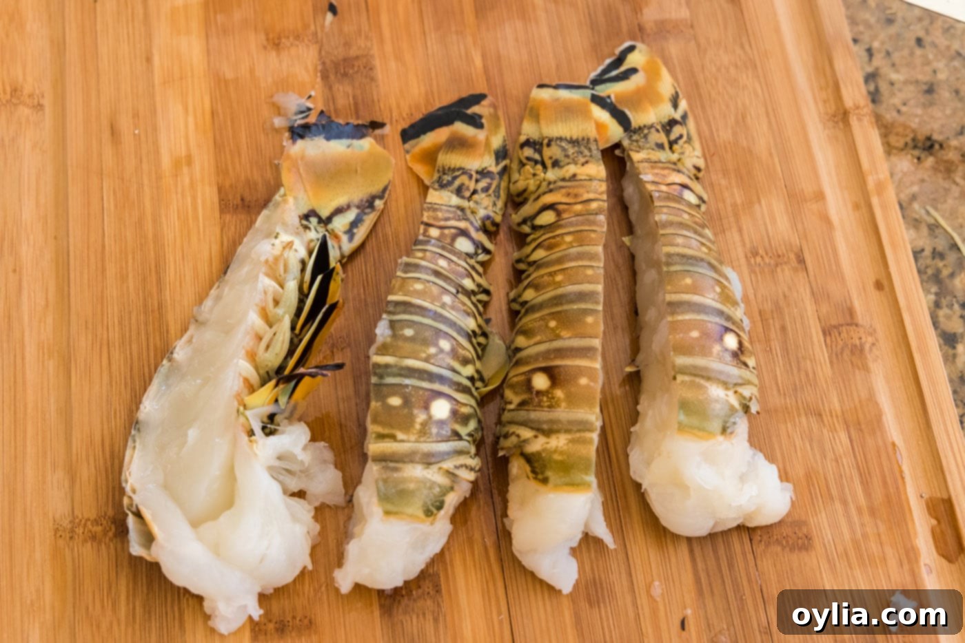 Fresh lobster tails cut in half lengthwise with kitchen shears, ready for steaming.