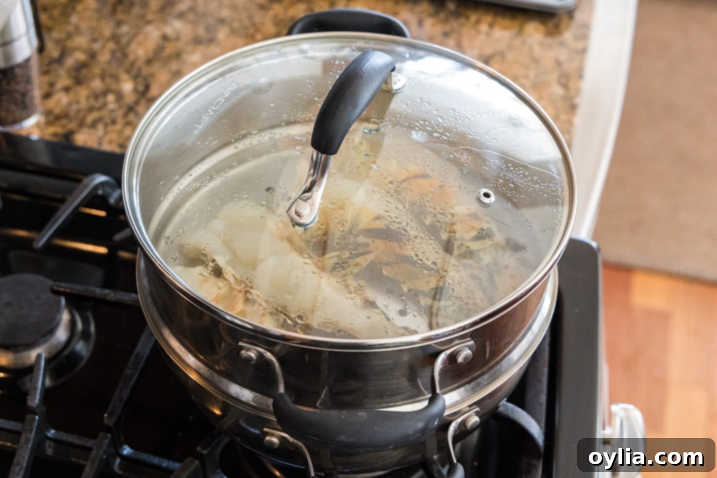 Two halves of lobster tails steaming in a pot, showing the vibrant orange color of cooked shell.