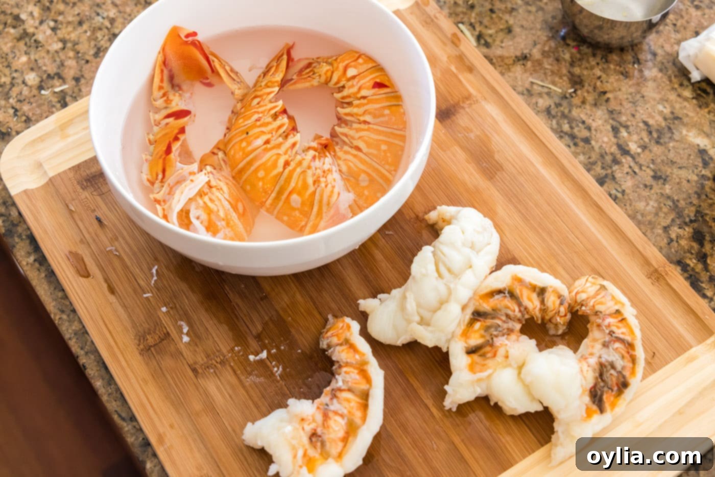Hands carefully removing the cooked lobster meat from the shells.