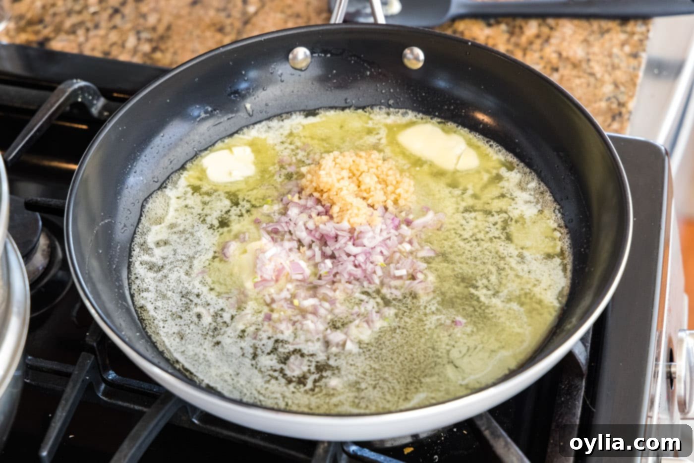 Melted butter in a skillet with minced shallots, garlic, and lemon juice simmering.