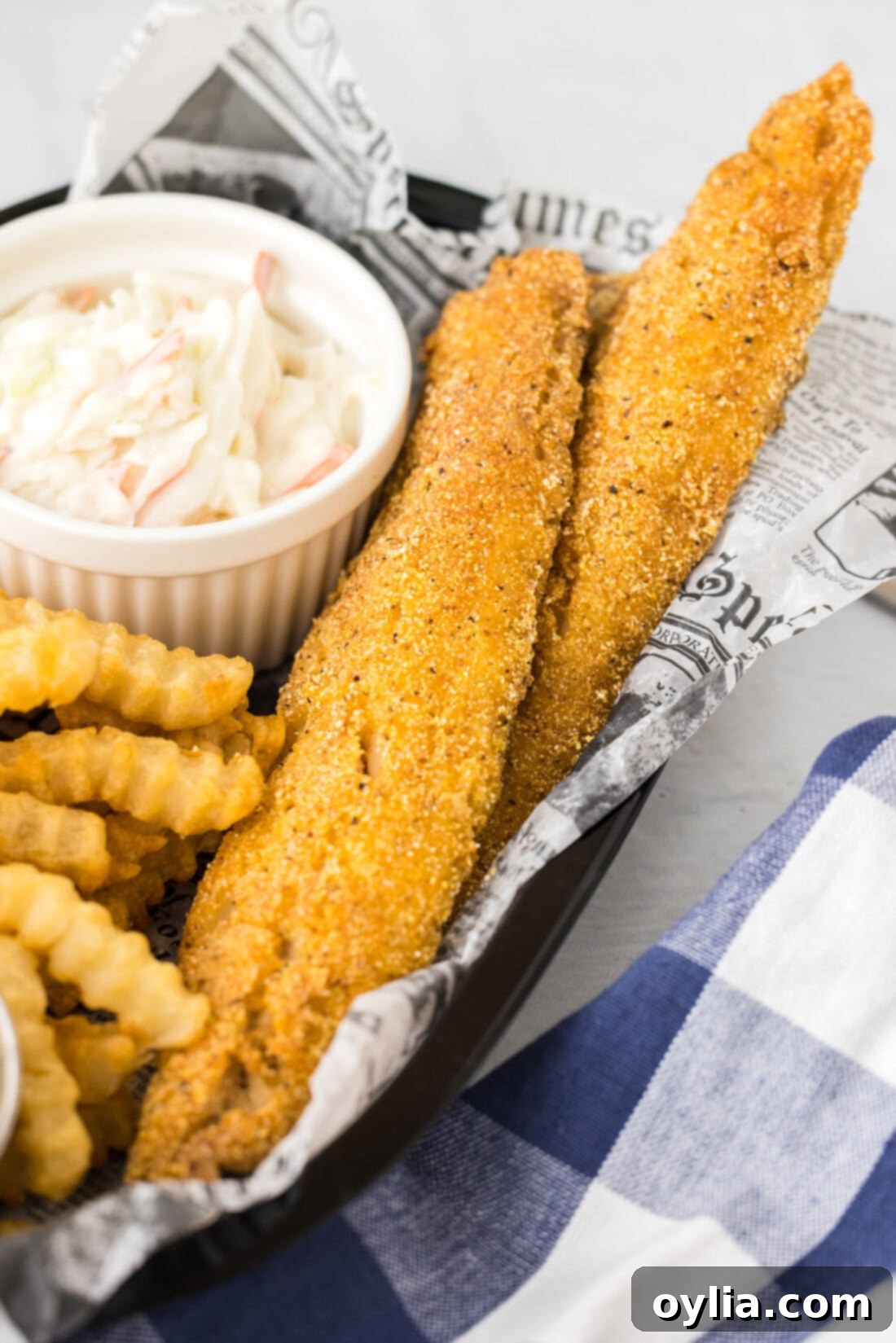 Golden Fried Whiting 2 Fried Whiting Fish in a basket with fries and lemon wedges, ready to be served