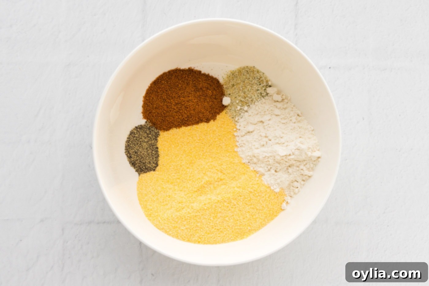 Golden Fried Whiting 5 Cornmeal, flour, Old Bay, garlic salt, and black pepper being whisked together in a bowl