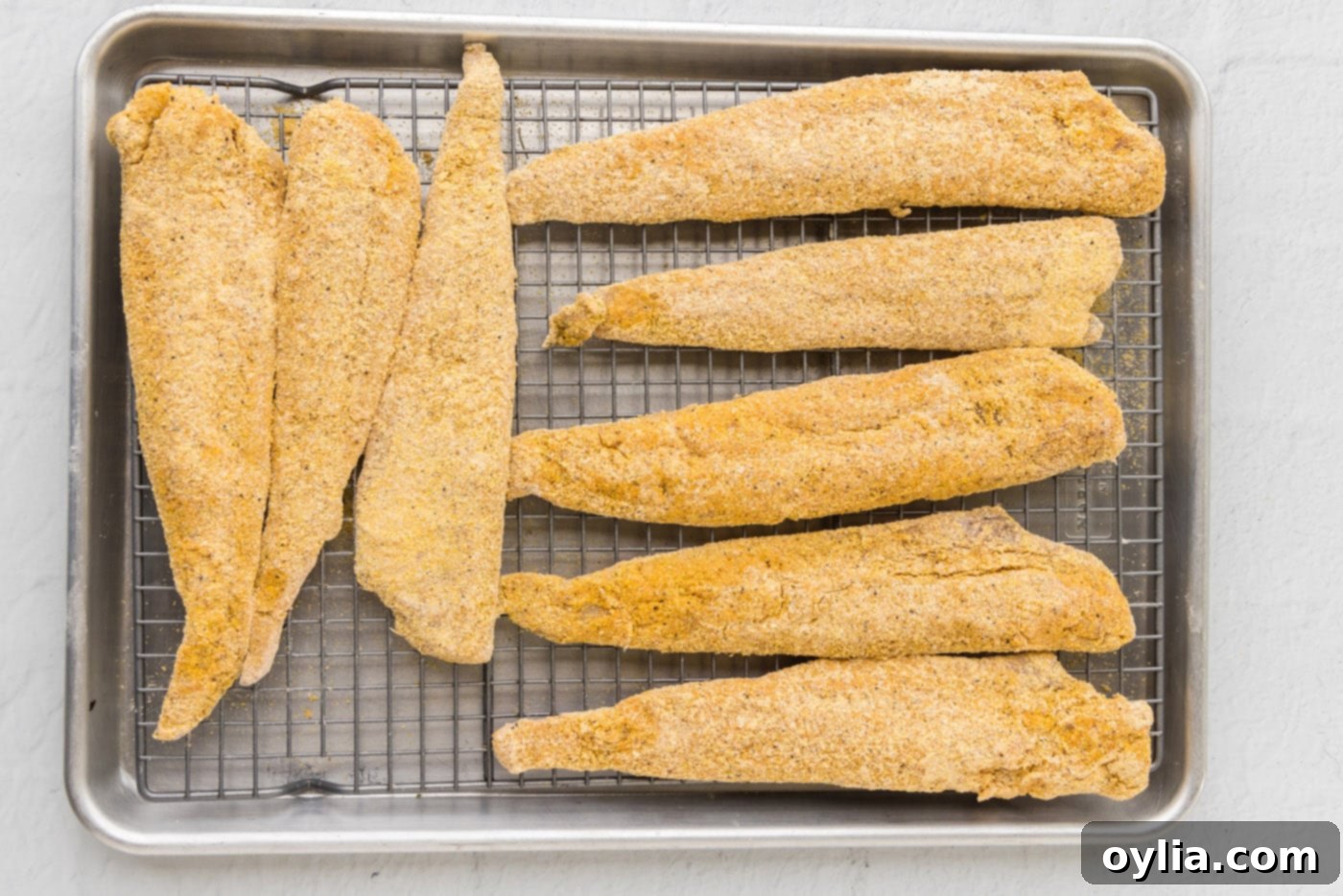 Golden Fried Whiting 9 Whiting fish fillets coated in cornmeal resting on a wire rack