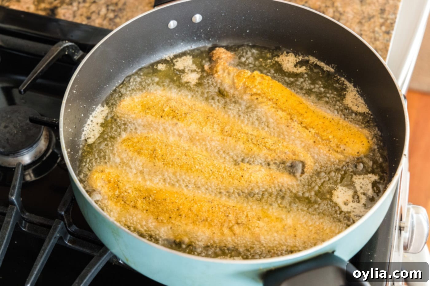 Golden Fried Whiting 10 Whiting fish fillets frying in hot oil in a skillet, turning golden brown