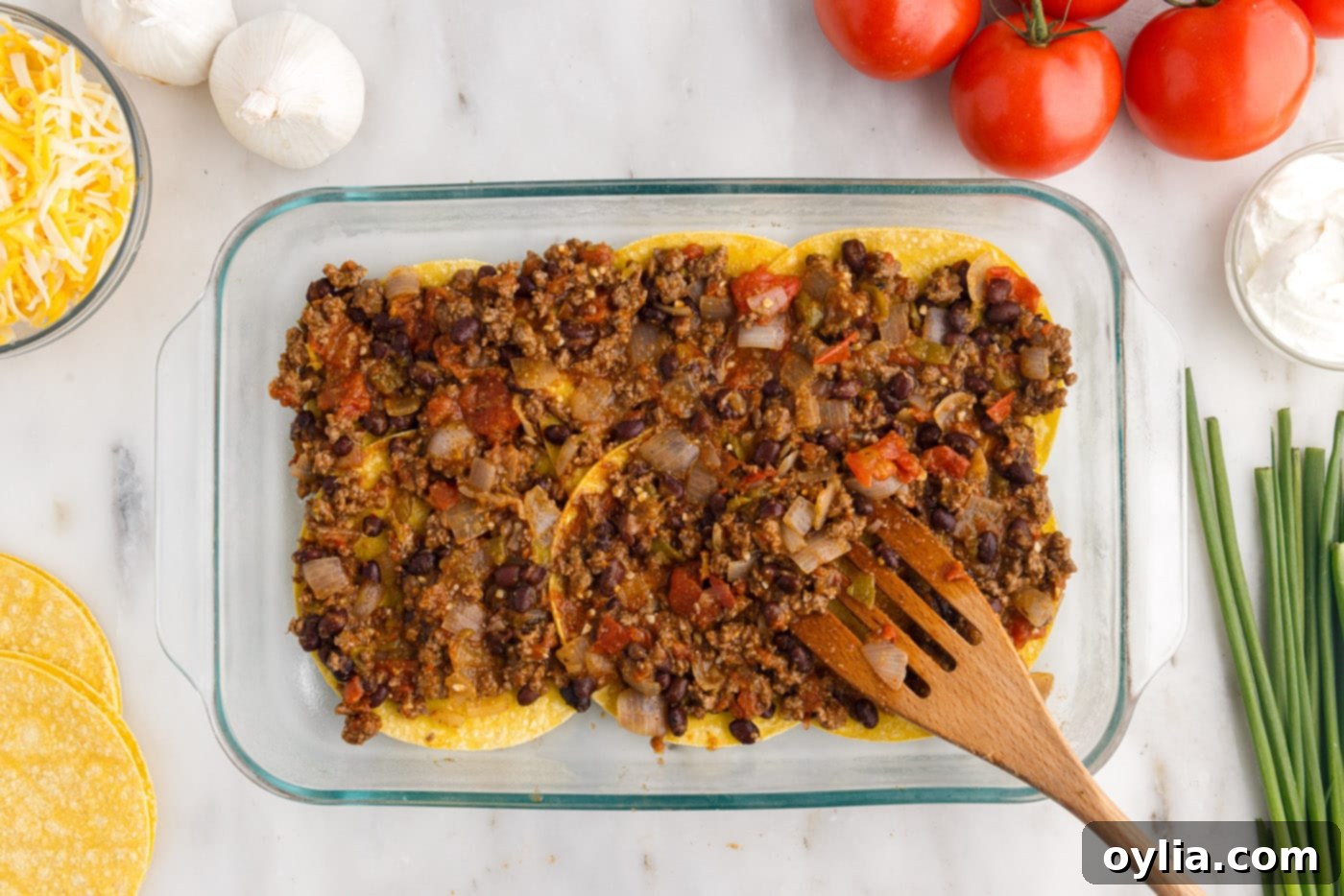spreading meat mixture over corn tortillas