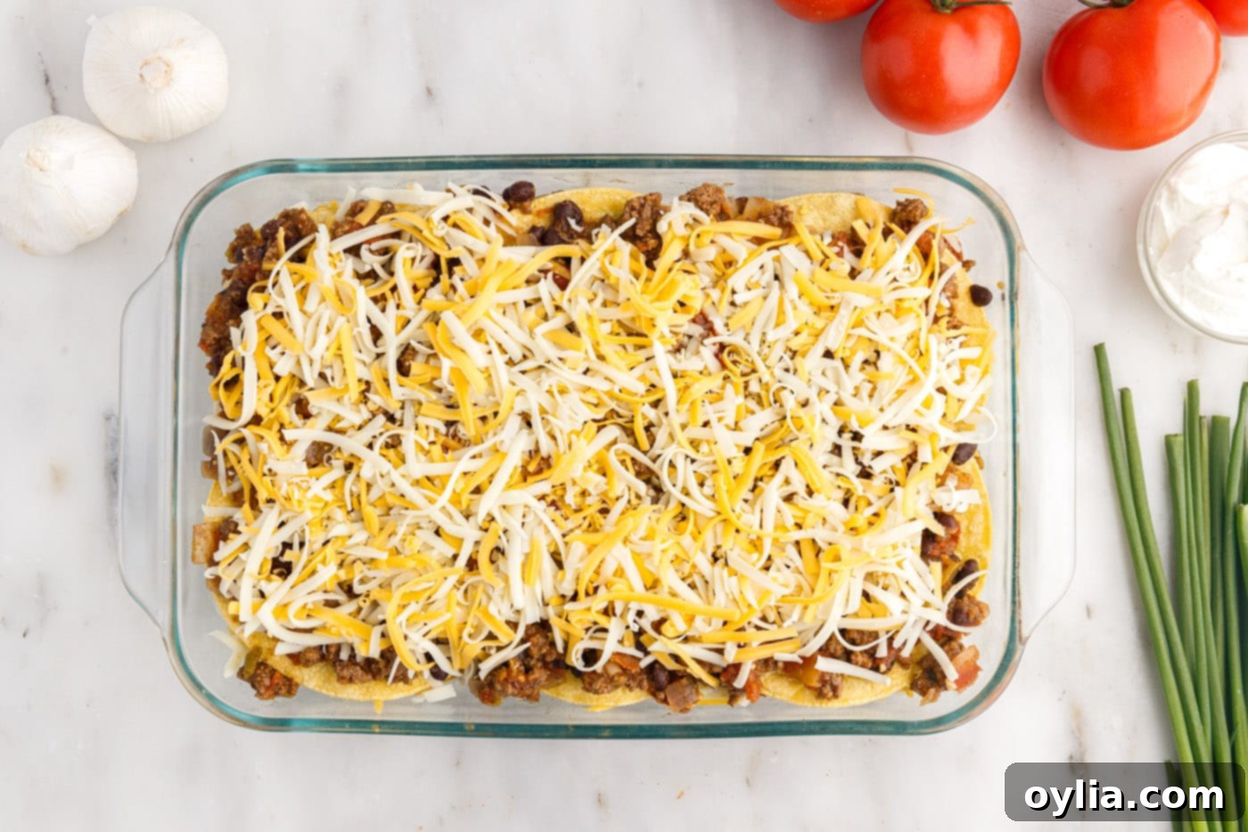 Shredded cheese on top of corn tortillas and beef mixture