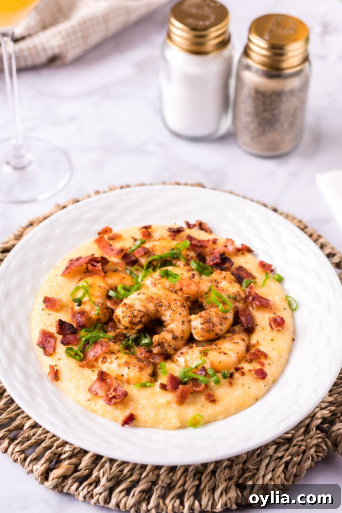 Southern Shrimp and Grits 14 A finished plate of Cheesy Shrimp and Grits garnished with bacon and green onions.