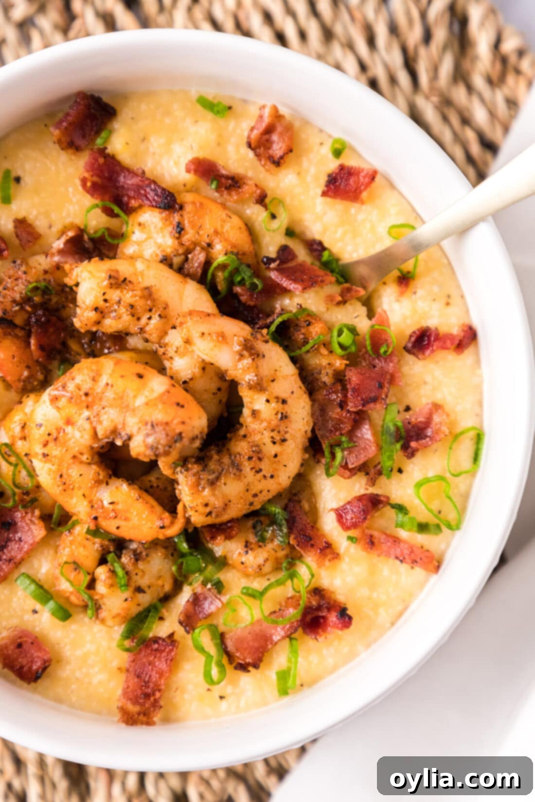 Southern Shrimp and Grits 3 A delicious bowl of Cheesy Cajun Shrimp and Grits with bacon and green onions.