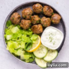 Flavorful Lamb Meatballs 11 Lamb Meatballs on a plate with tzatziki and lettuce