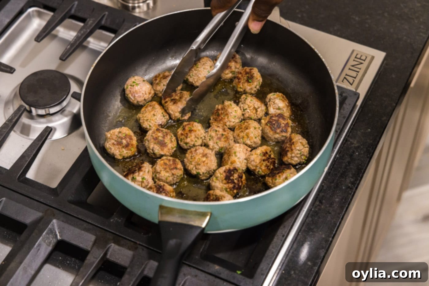 turning meatballs in a skillet