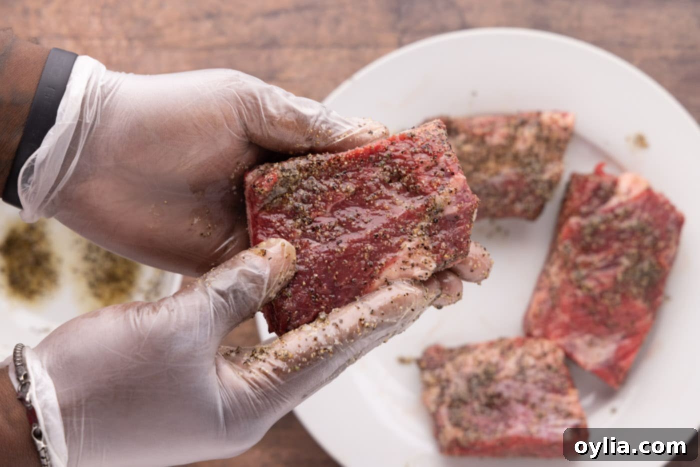 rubbing pepper and garlic salt on beef short ribs