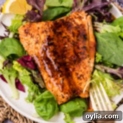 Piece of salmon on a plate with Salmon Sauce on top, glistening