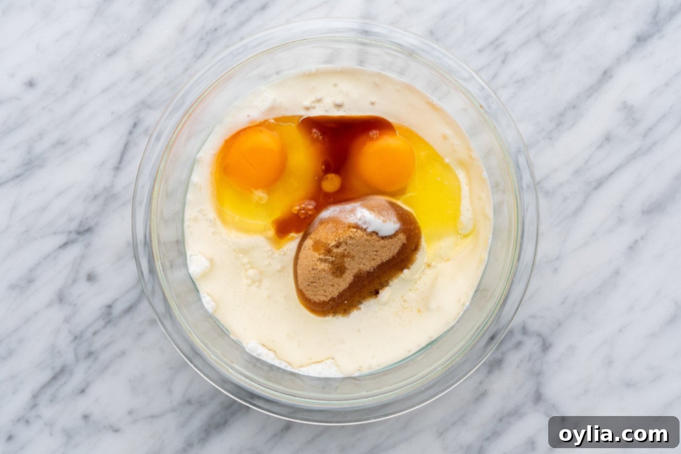 Granulated sugar, brown sugar, buttermilk, oil, eggs, and vanilla extract in a bowl before whisking.