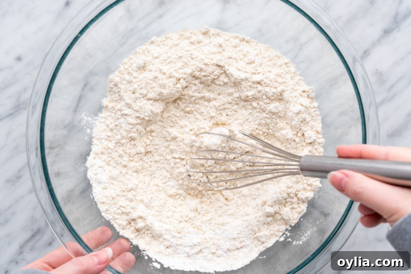 Whisking together flour, baking powder, baking soda, and salt in a large bowl.