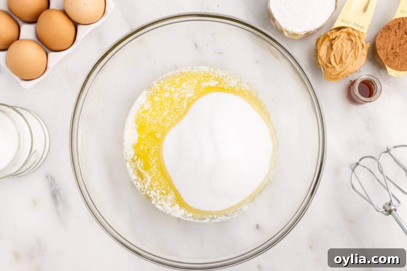 Melted butter and sugar being beaten in a mixing bowl for brownie batter.