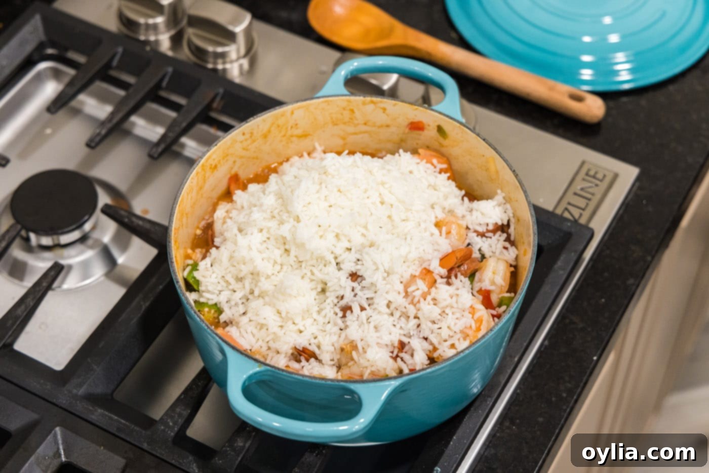 white rice on top of jambalaya in a dutch oven