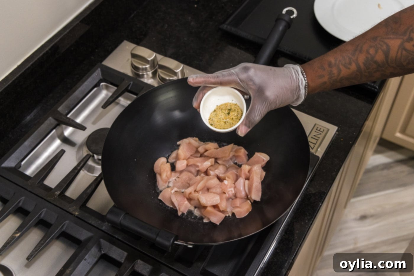 seasoning chicken in wok with garlic salt while stir-frying