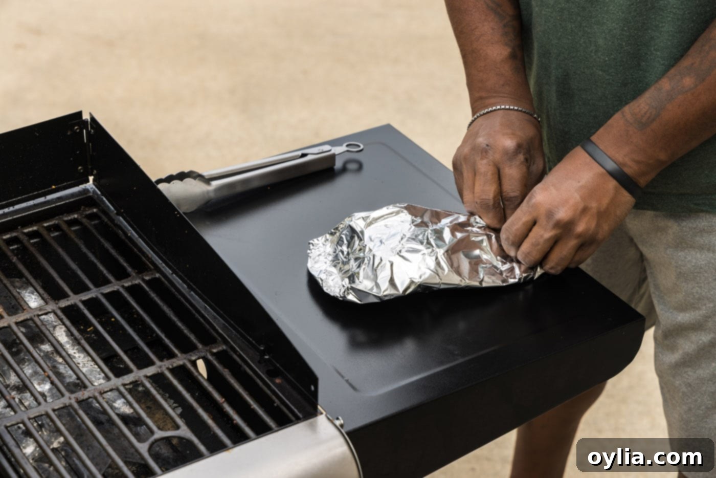 Another image of grilled lobster tails wrapped in aluminum foil for resting