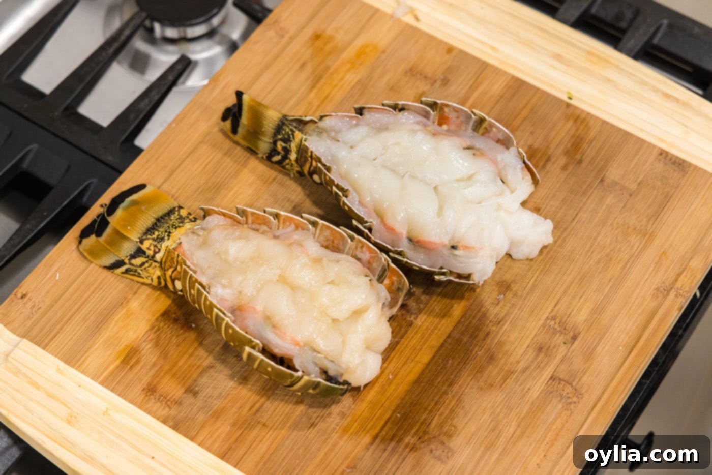 A perfectly butterflied lobster tail displayed on a cutting board, ready for seasoning
