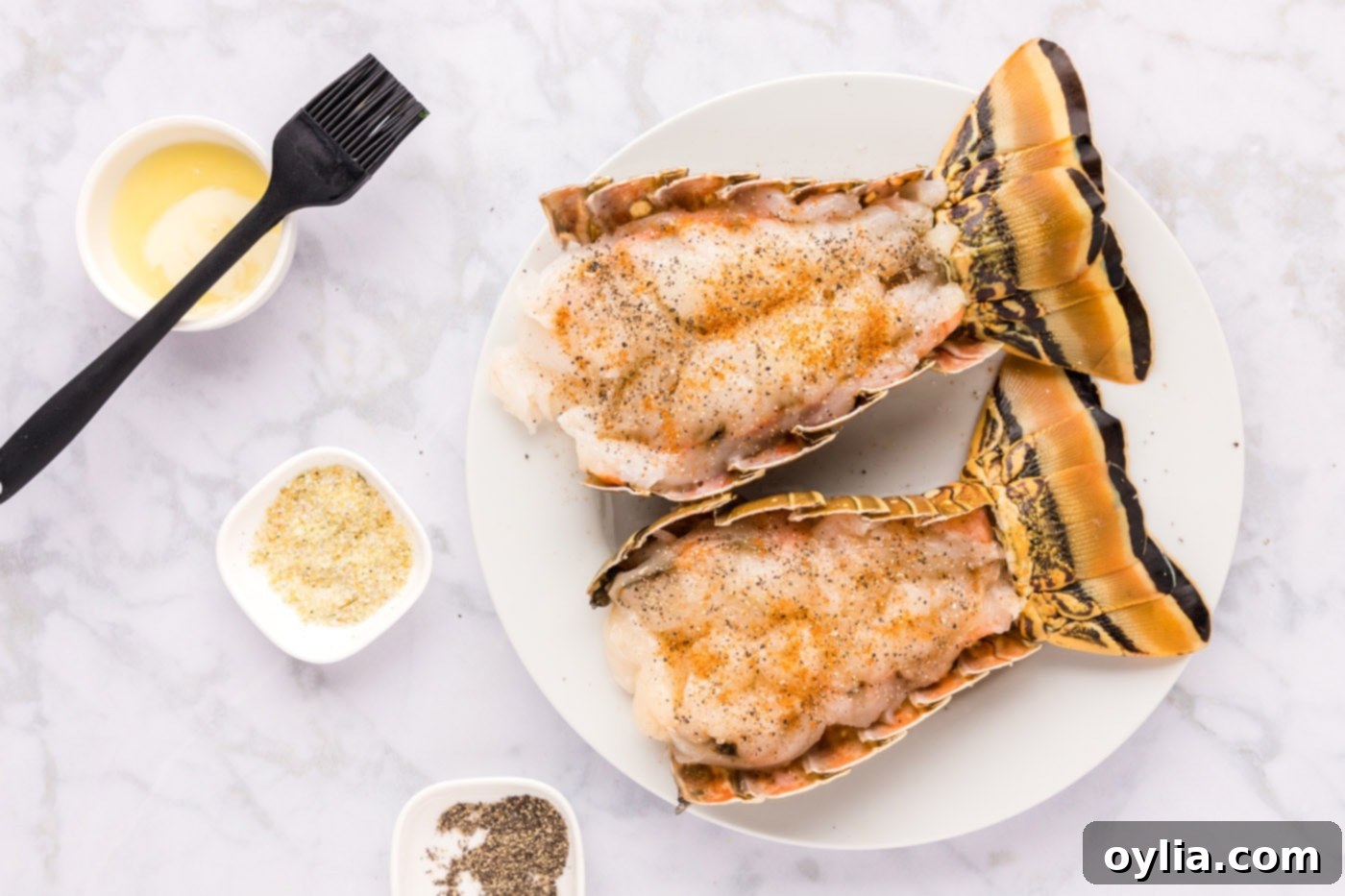 Raw lobster tail meat generously seasoned with black pepper, garlic salt, and Old Bay