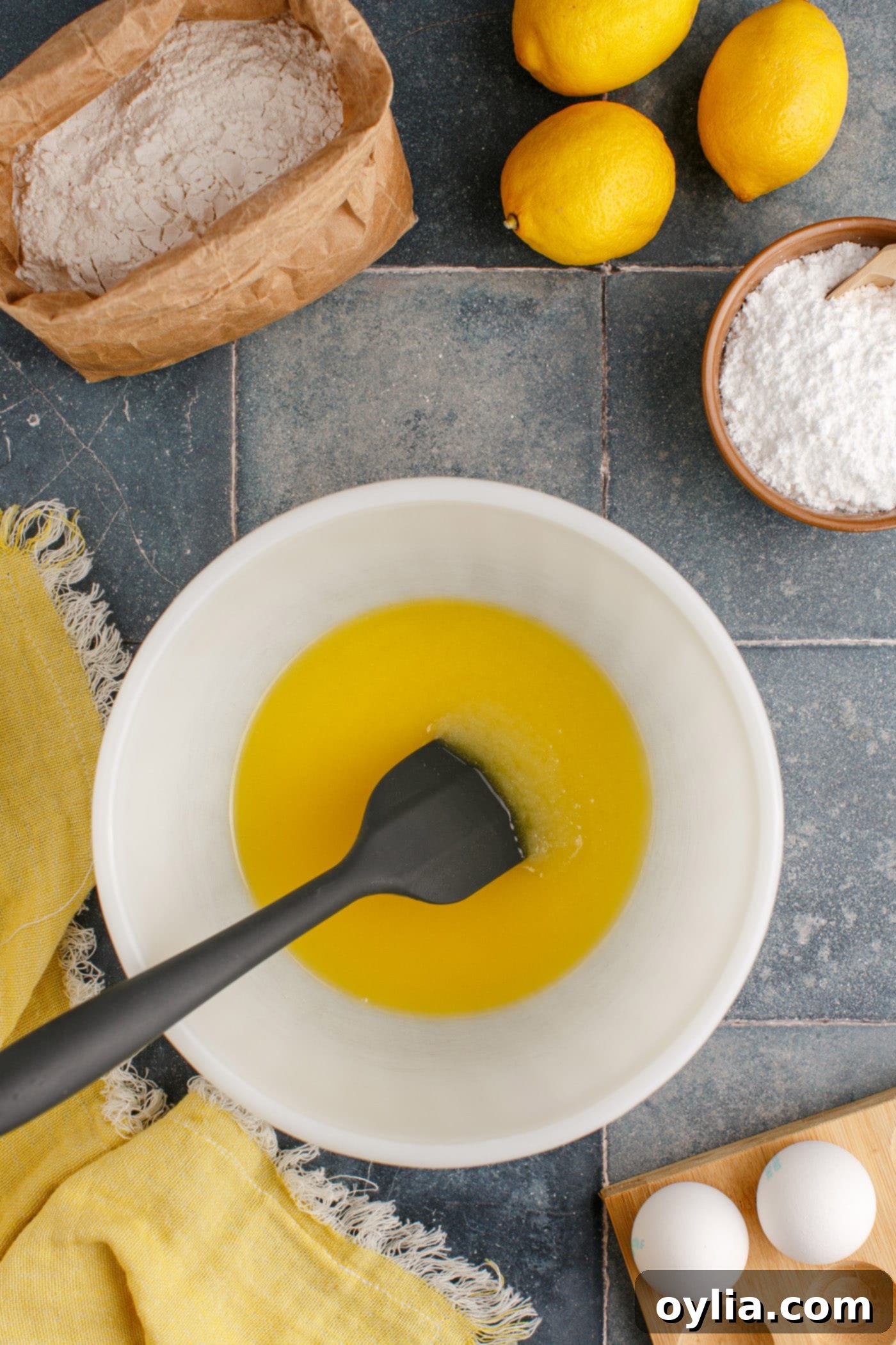 Melted butter and granulated sugar being mixed together in a bowl, creating a smooth, golden base for the lemon brownies.