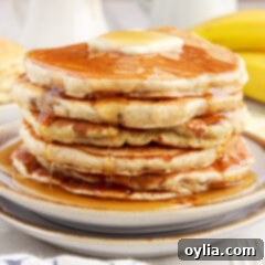 Fluffy Banana Bliss 14 Stack of Banana Pancakes with butter on top and syrup dripping down, ready to be served.