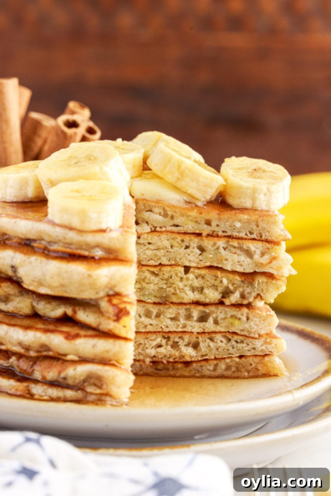 Fluffy Banana Bliss 3 Close-up of a stack of fluffy banana pancakes with a slice taken out, showing the moist, tender interior.