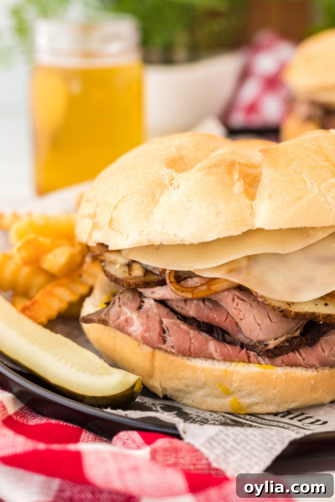 Tender Roast Beef Masterpiece 2 Close up of a Roast Beef Sandwich, showcasing layers of meat, cheese, onions, and potatoes
