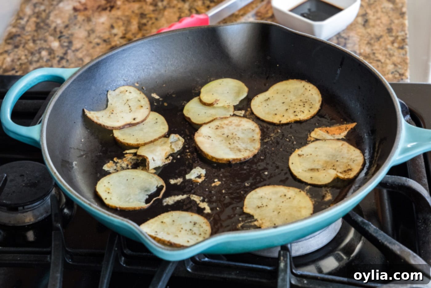 sliced potatoes in a skillet with oil, turning golden brown