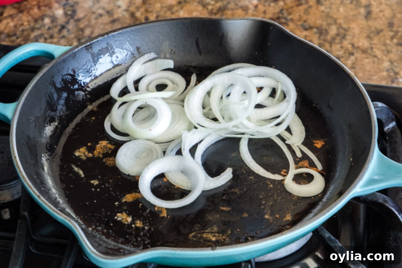 sliced onion in a skillet, beginning to soften