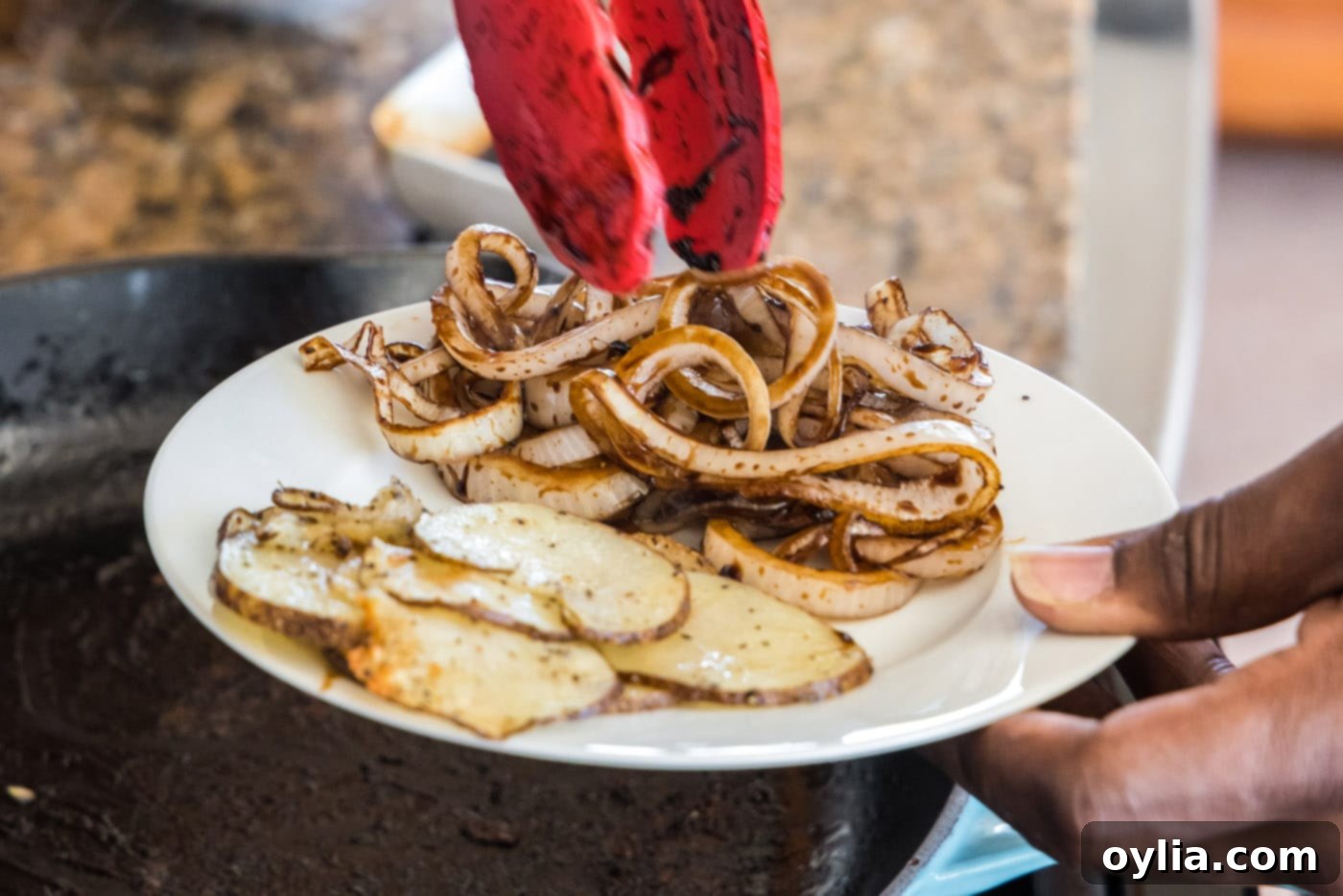 glazed onions and sliced potatoes on a plate, ready for assembly