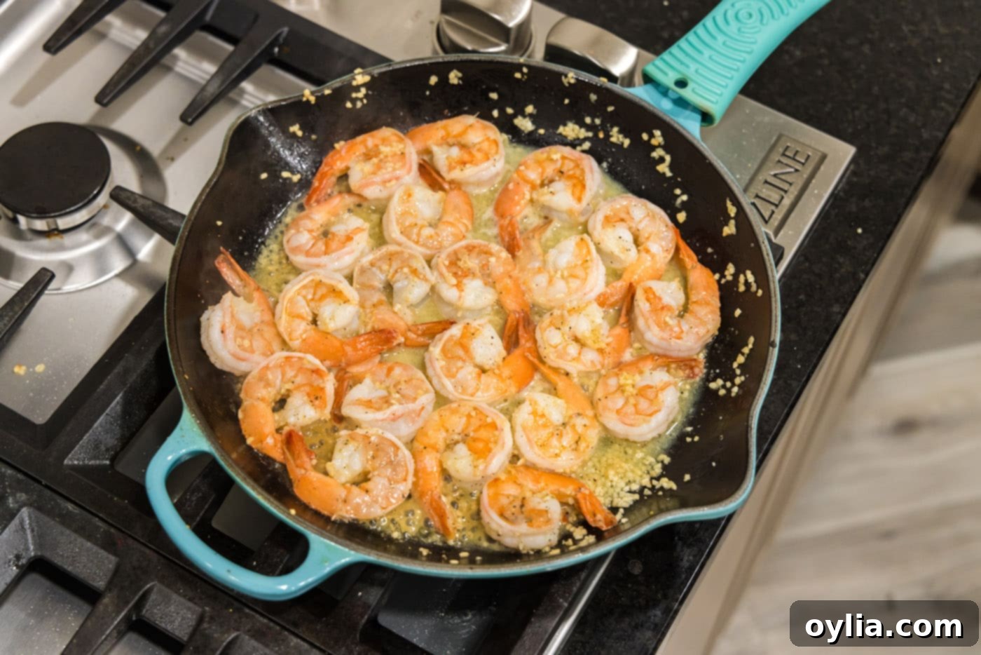 Close-up of perfectly cooked shrimp simmering in a rich lemon garlic butter sauce in a skillet, ready to serve.