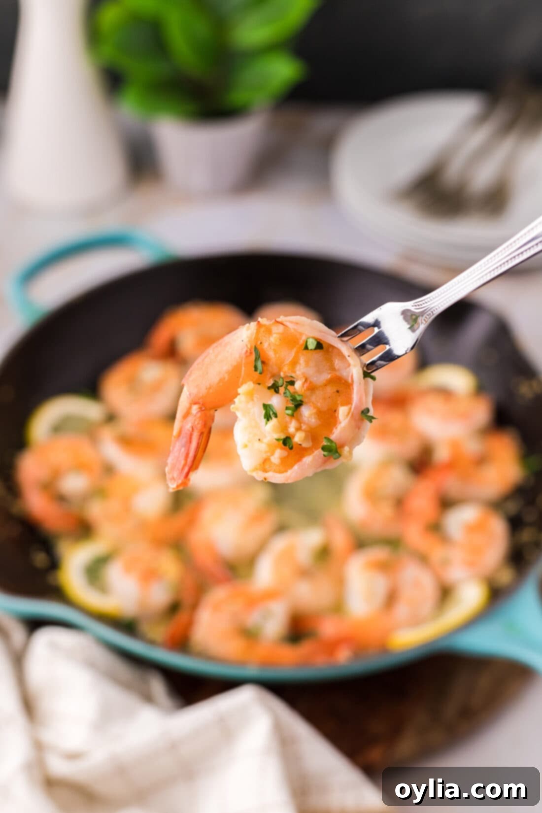 Perfectly cooked Garlic Butter Shrimp on a seafood fork, glistening with sauce and ready to be enjoyed