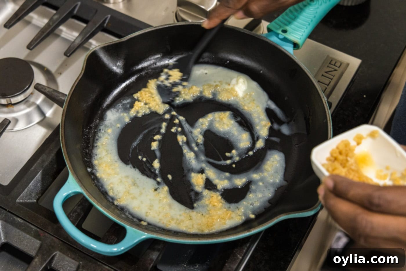 Melted butter in a large skillet with minced garlic sizzling and becoming fragrant.
