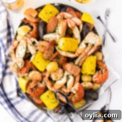 Coastal Seafood Feast 12 Seafood Boil in a metal serving platter with seafood utensils on the side