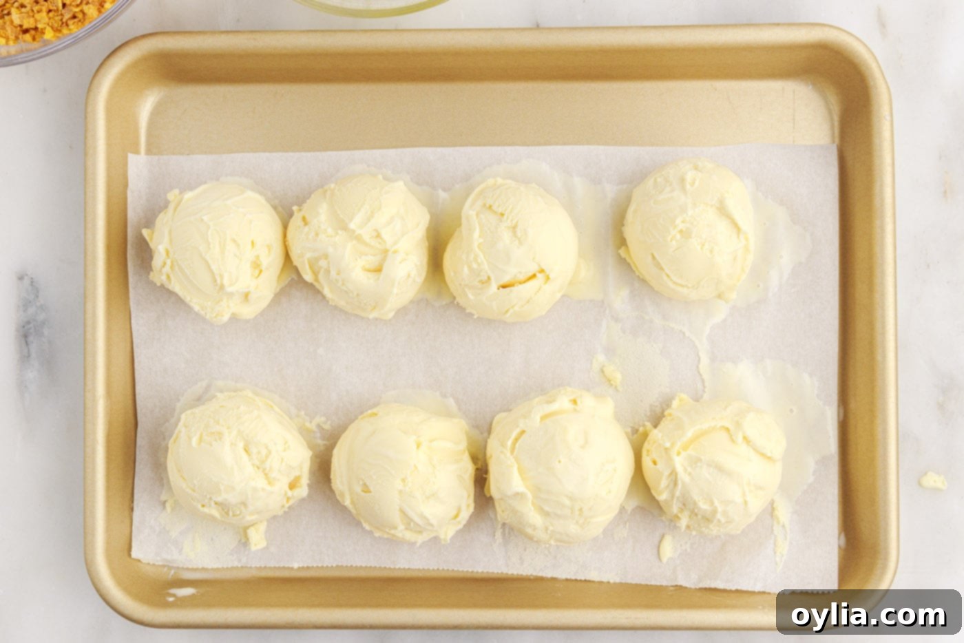ice cream balls on parchment lined baking sheet