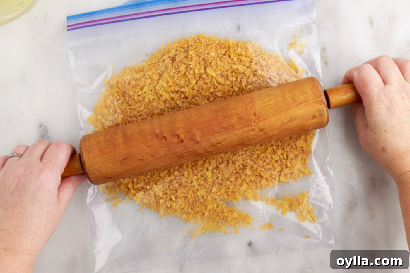 crushed cornflakes in a bag with rolling pin