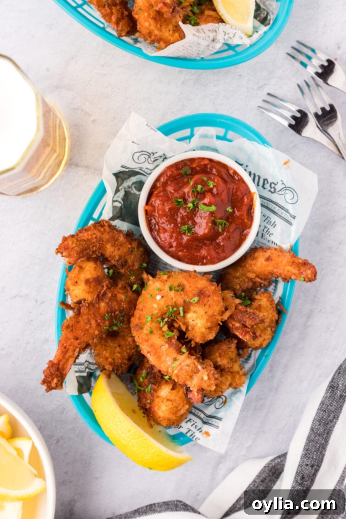 Coconut Shrimp in a basket with a bowl of cocktail sauce