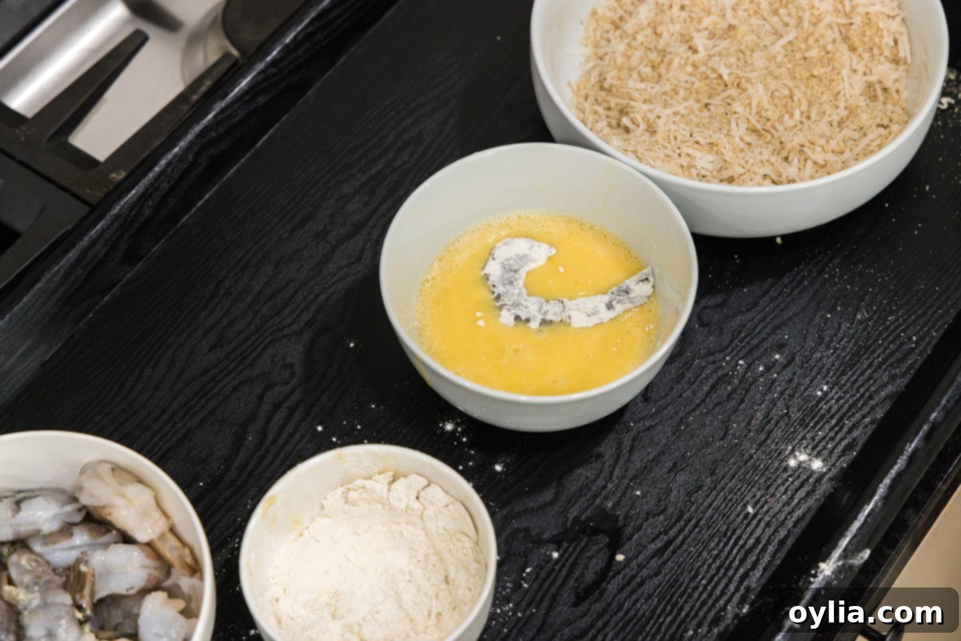 dipping floured shrimp into egg