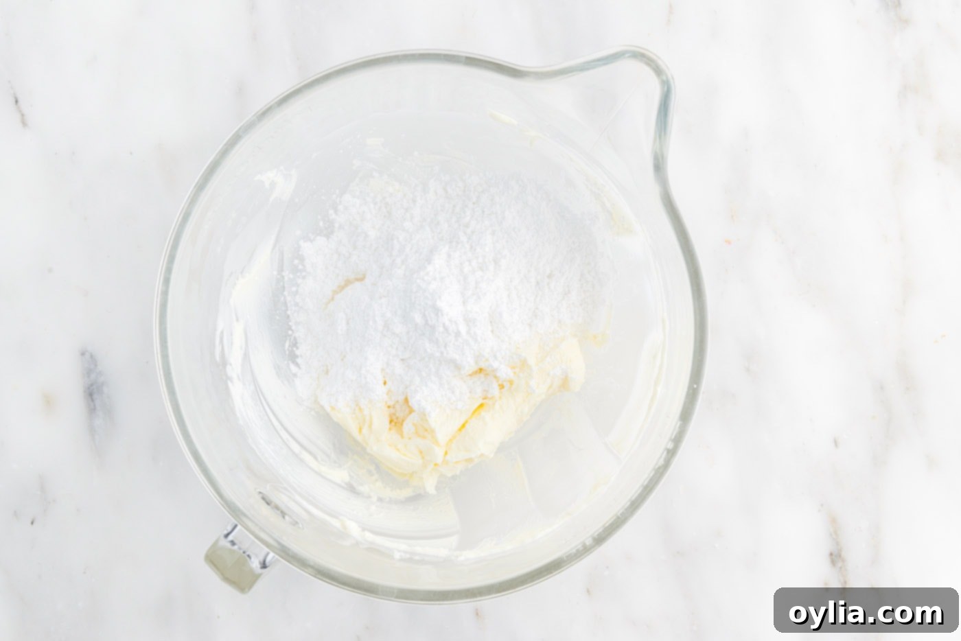 powdered sugar added to butter in a stand mixer bowl