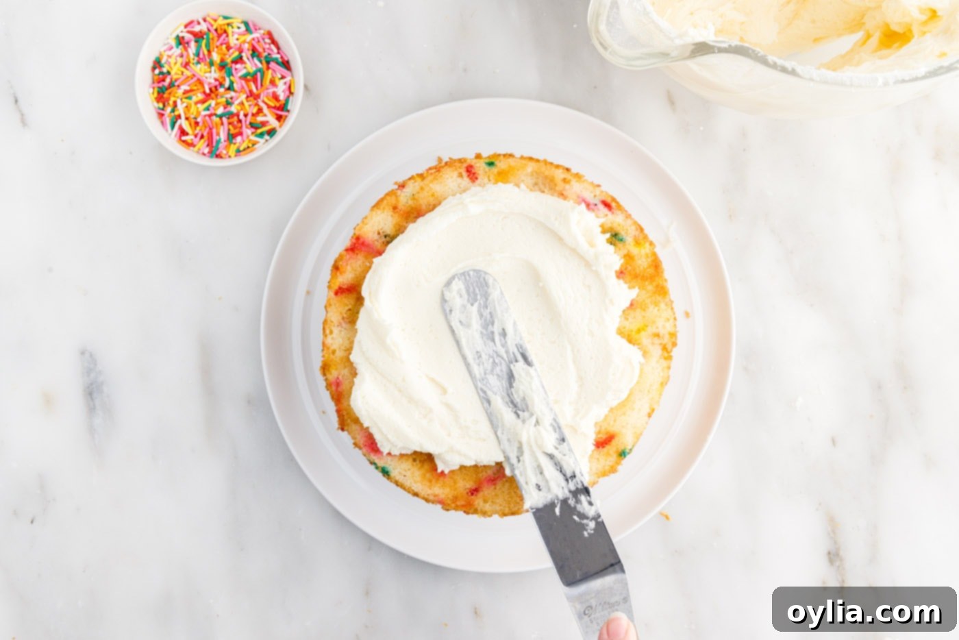 spreading frosting over cake layer