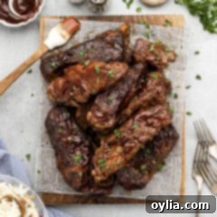 Slow Cooker Barbecued Country Style Ribs resting on a parchment lined wooden platter