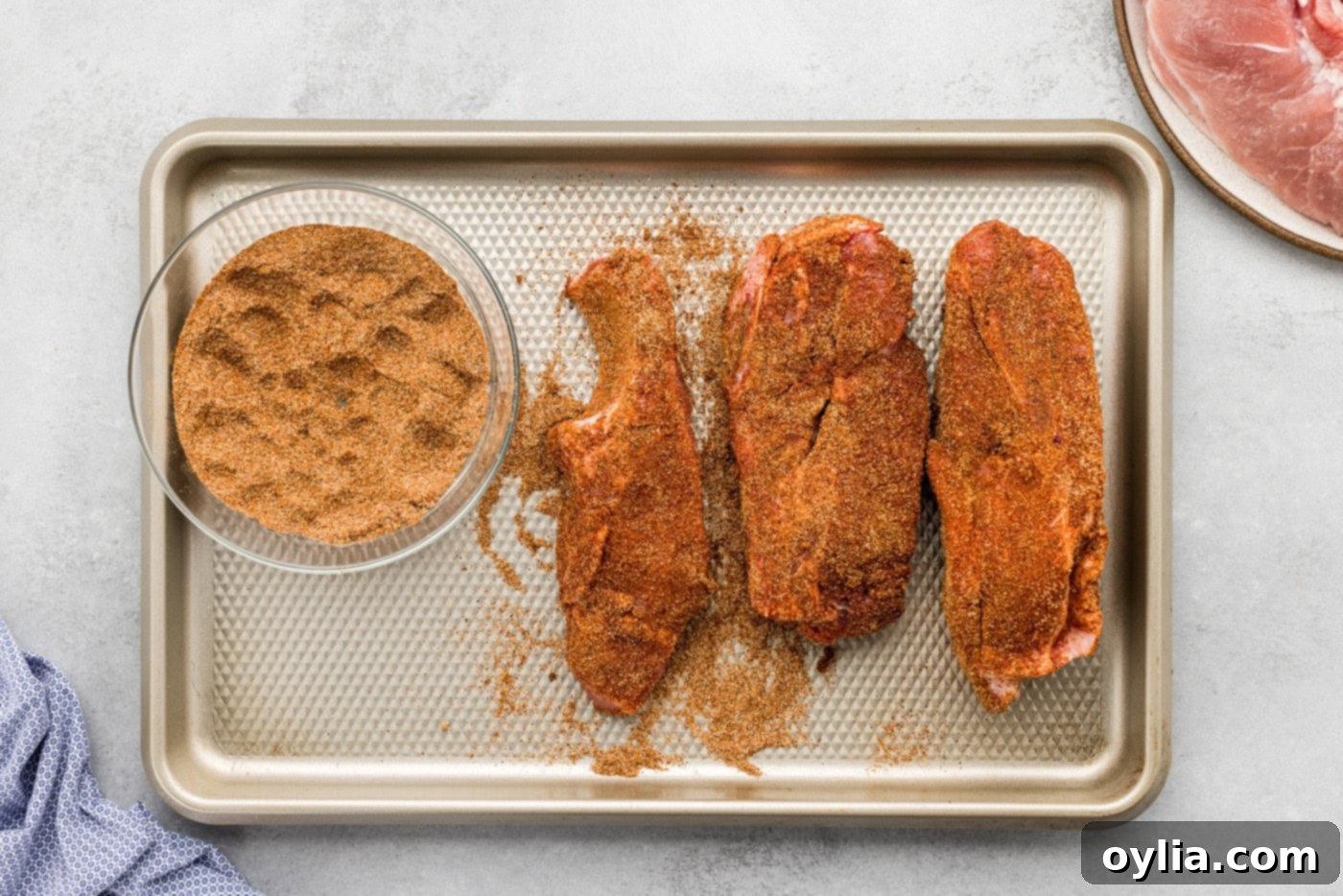 country style ribs rubbed with seasonings on a baking sheet