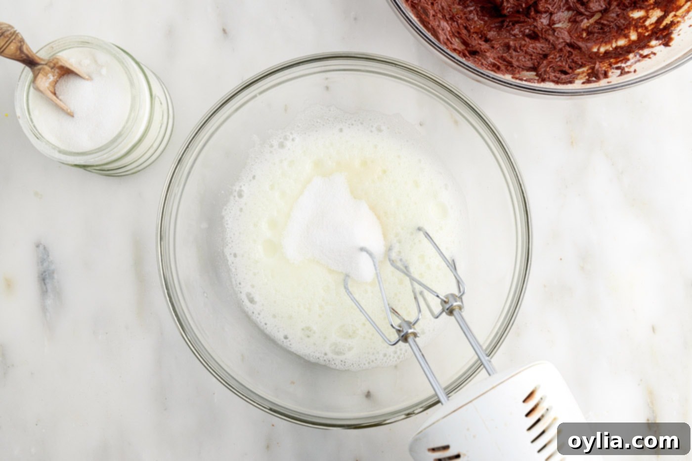 Molten Chocolate Delight 7 whipping egg whites using a hand mixer to create a frothy texture